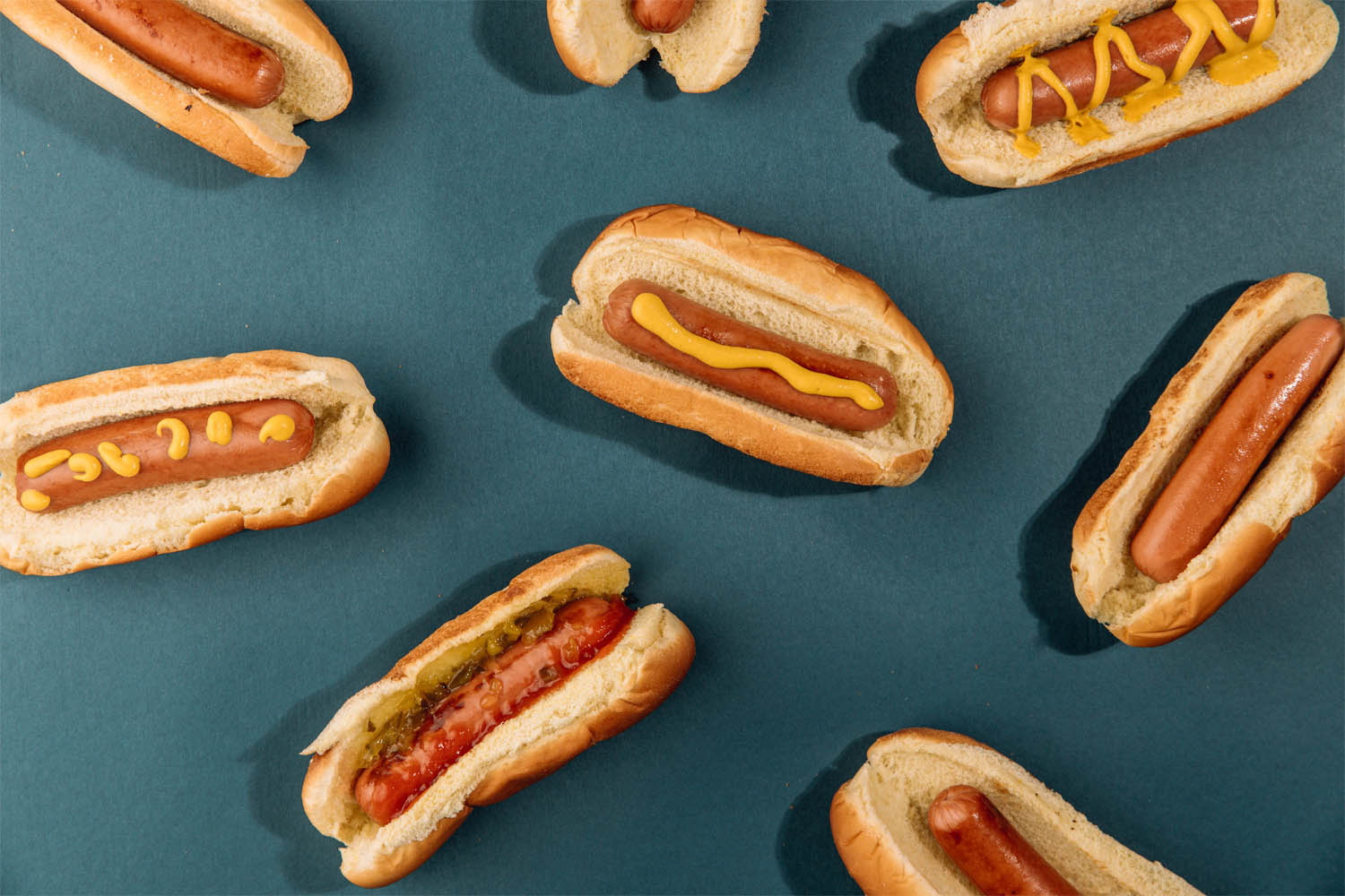 Hot dog sandwiches on a teal background