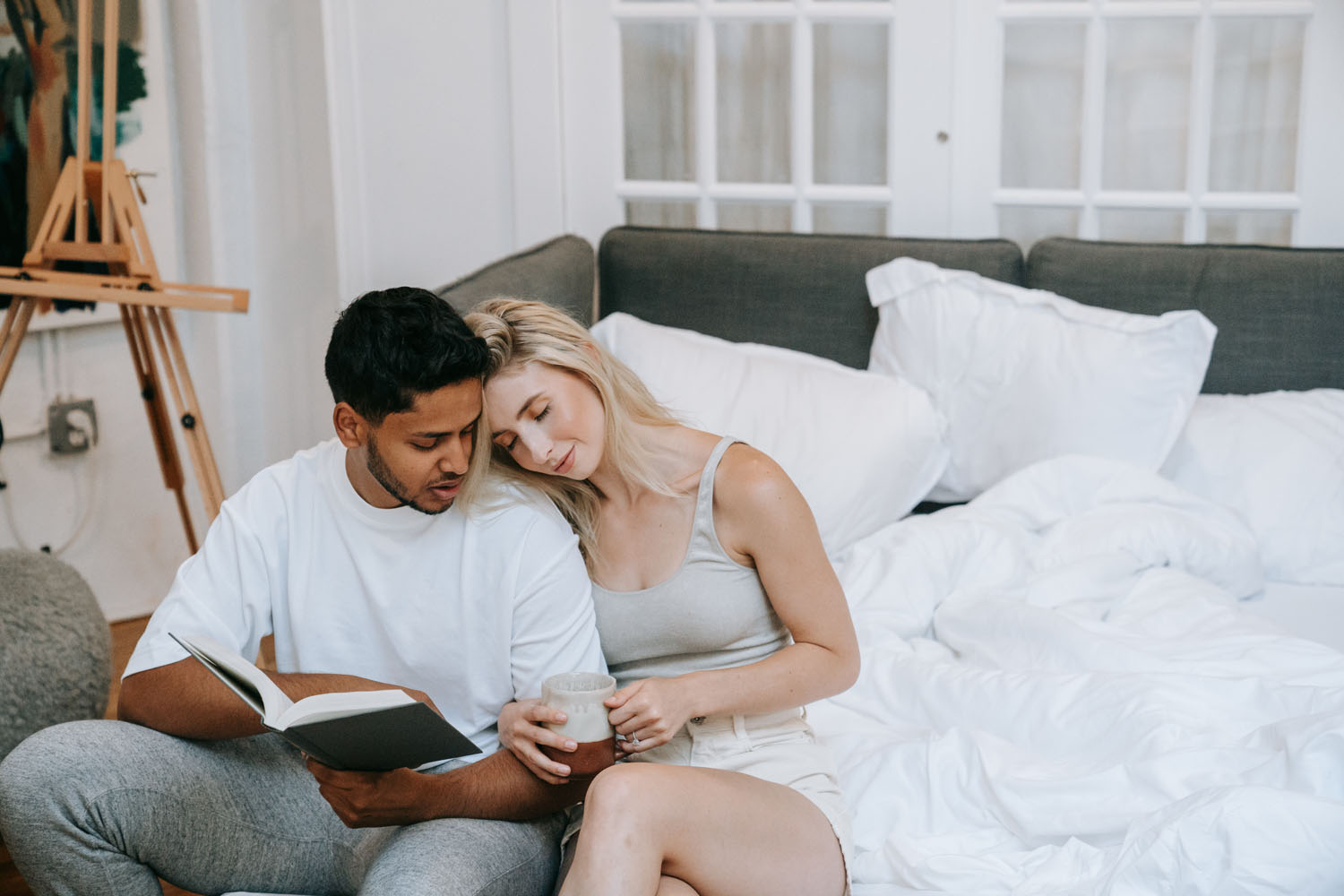 A man reading a book to a blonde woman